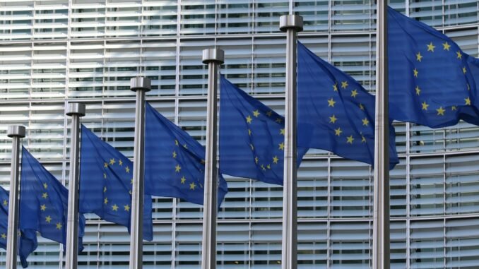 Flags of the European Union as the first regulations from the EU AI Act come into force with policies that set strict rules on how businesses use the technology for their operations and severe penalties for failures.