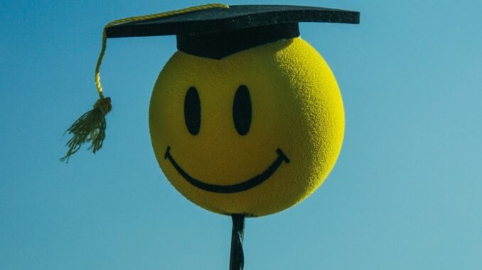 A smiley face wearing a graduation cap illustrating Carl by the Autoscience Institute, the first AI system crafting academic research papers to pass a rigorous double-blind peer-review process and raising questions about ethics including the role of artificial intelligence in academic settings.